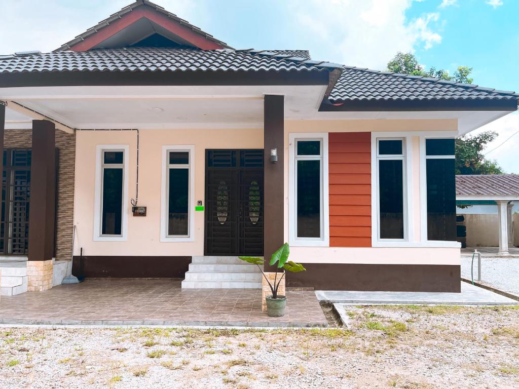 een klein huis met een zwarte deur bij Homestay Ar-Rayyan 2 Kota Bharu in Kota Bharu