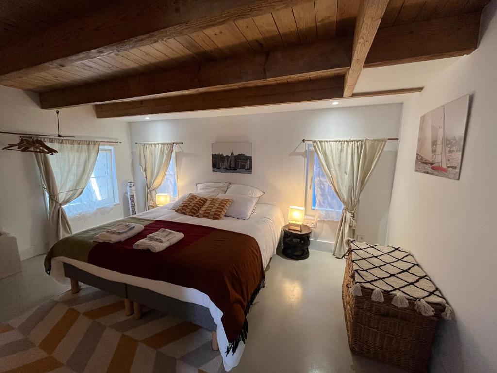 a bedroom with a large bed and two windows at LE CLOS DE FLO 17 in Saint-Rogatien