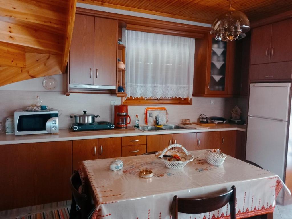 a small kitchen with a table and a microwave at Maroulas House in Chrysomiléa
