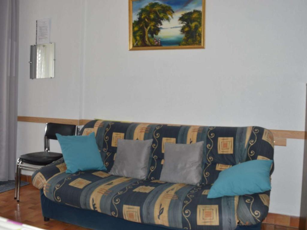 - un canapé dans le salon avec une photo sur le mur dans l'établissement Appartement familial proche plage avec terrasse, parking privé, au Grau-du-Roi - FR-1-250-136, au Grau-du-Roi