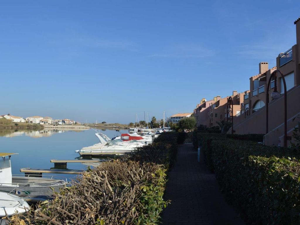 une passerelle à côté d'une rivière avec des bateaux amarrés dans l'établissement Appartement T2 Cabine 6 pers proche plage, parking, BBQ - FR-1-225D-4, à Saint Cyprien Plage