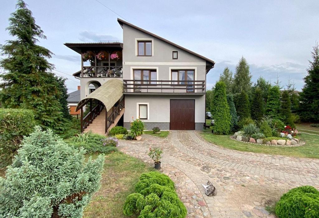 a house with a balcony and a yard at Pokoje w miasteczku przy Puszczy Bialowieskiej in Hajnówka