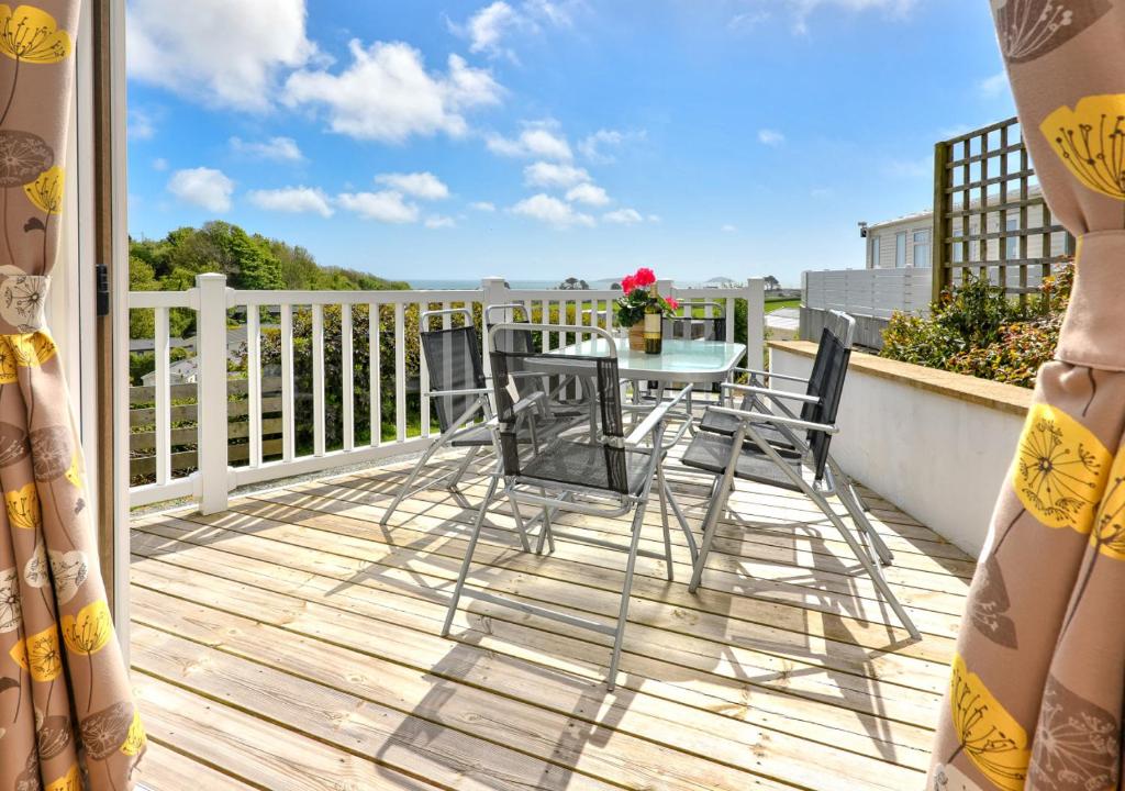 a patio with a table and chairs on a balcony at B12, Tal y Fan in Abersoch