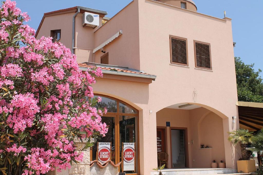 a building with pink flowers in front of it at Apartments Lukas in Medulin