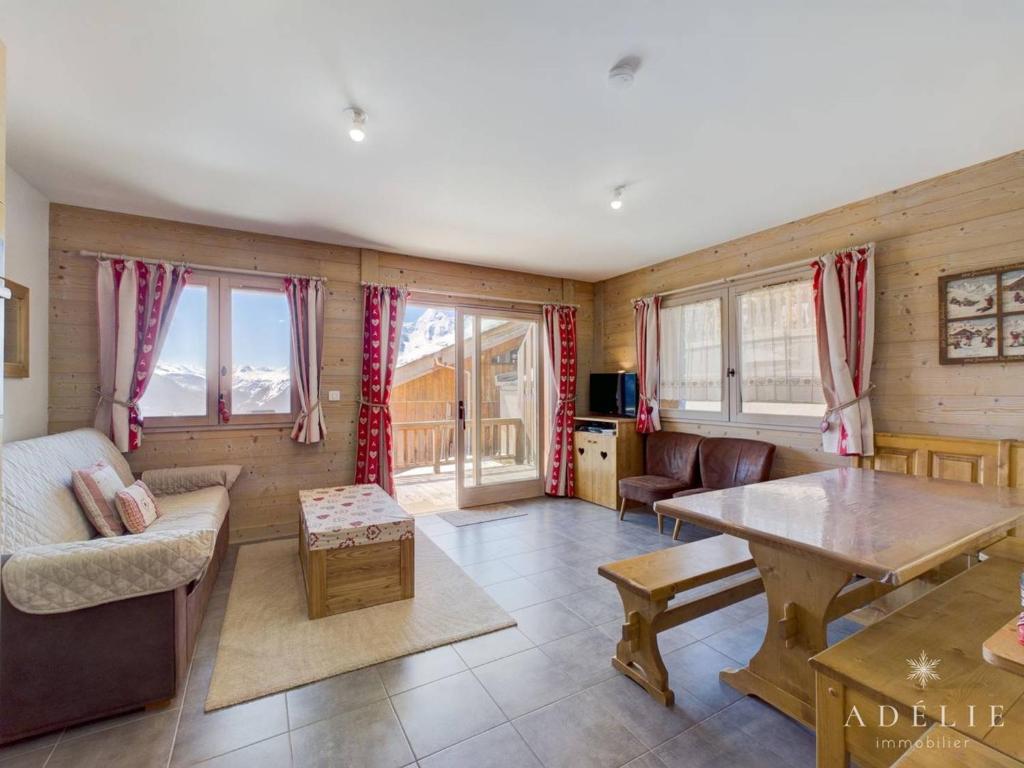 un salon avec un canapé et une table dans l'établissement Appartement Moderne - 4 Pers, Parking, Wifi, Terrasse - FR-1-398-614, à Montvalezan