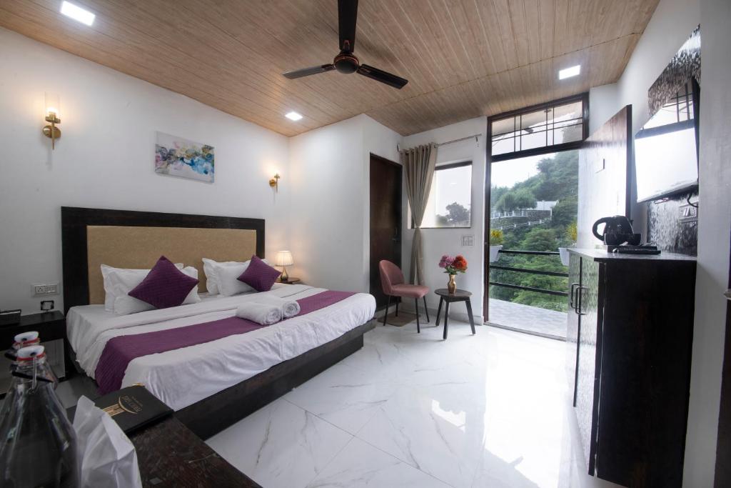 a bedroom with a bed and a large window at PerfectStayz Mussoorie Hills in Mussoorie