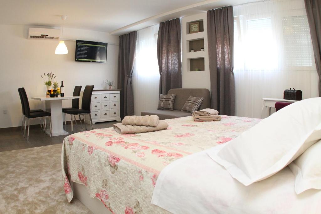 1 dormitorio con 1 cama, mesa y sillas en Studio Apartments Mirakul, en Split