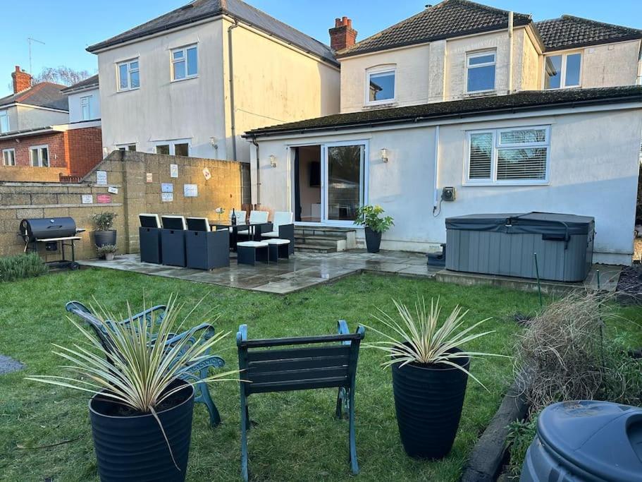 a yard with a bench and plants in front of a house at Dolphin Retreat close to Beaches and Harbour in Poole