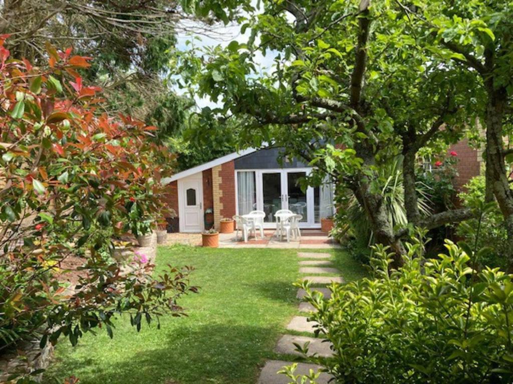 a garden with a brick house with a lawn at Walnut Cottage in Newton Ferrers