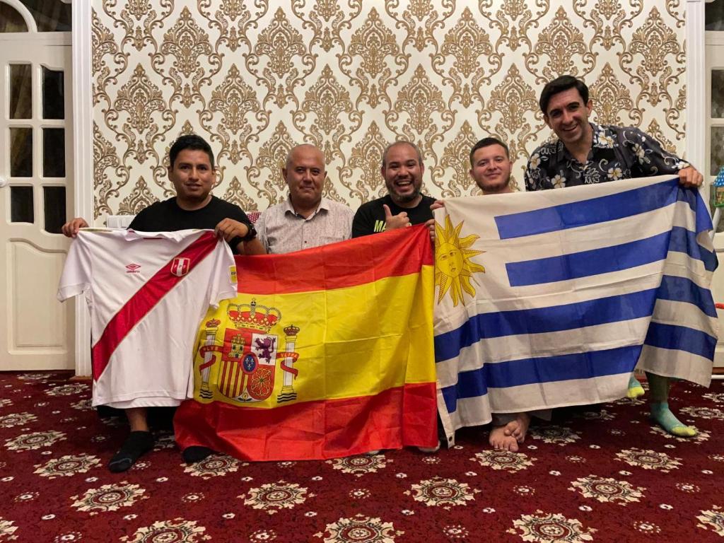 un grupo de hombres sosteniendo banderas en una habitación en Khiva Karim Sulton, en Khiva