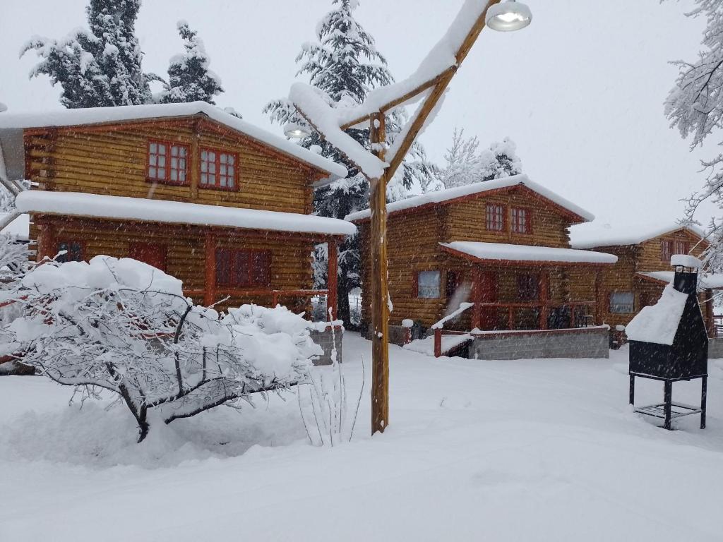 a log cabin in the snow in front at Rincón Lejano in Potrerillos