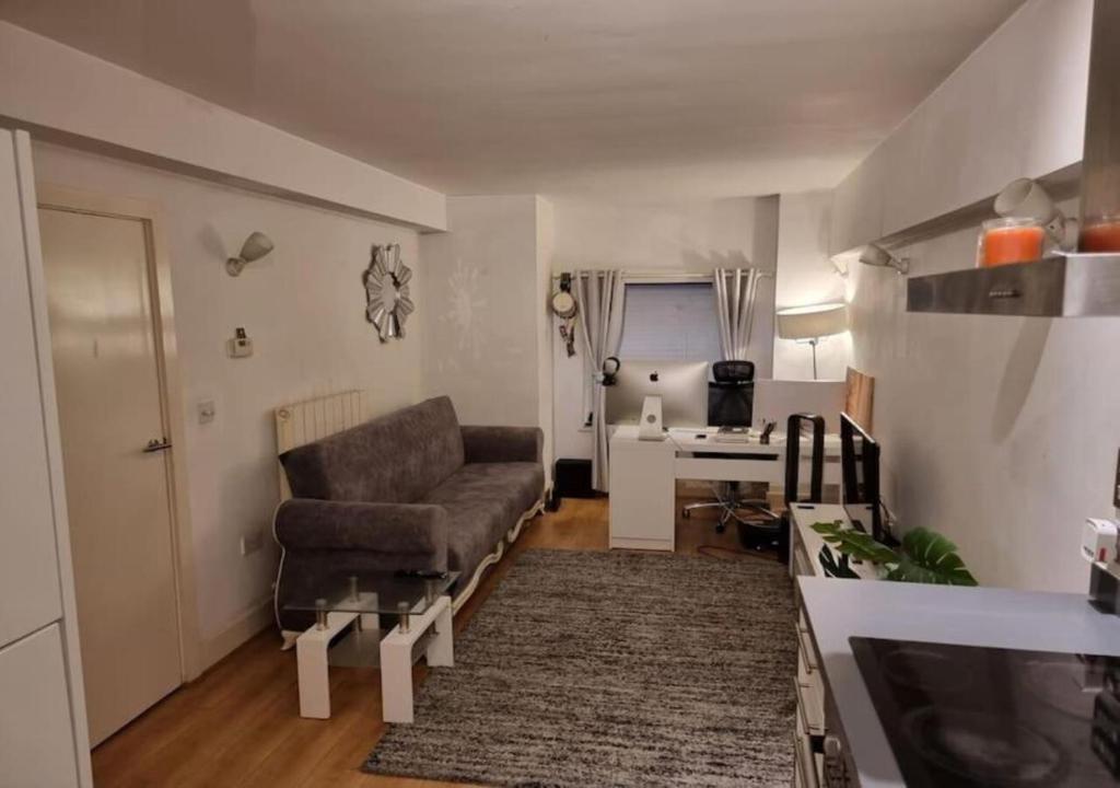 uma sala de estar com um sofá e uma secretária em Your Riverside Home em Woolwich