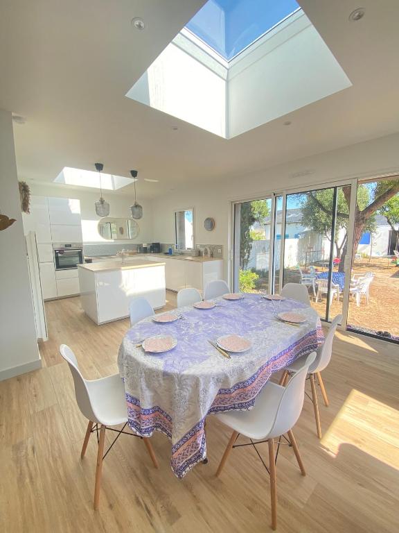 une cuisine et une salle à manger avec une table et des chaises dans l'établissement Maison de famille à Batz sur Mer proche plages, à Batz-sur-Mer