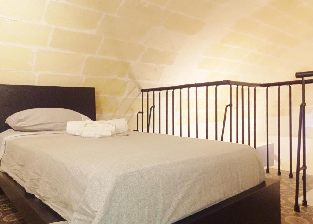 łóżko z białą pościelą i poduszkami w sypialni w obiekcie STRADONE 132 w mieście Gravina in Puglia