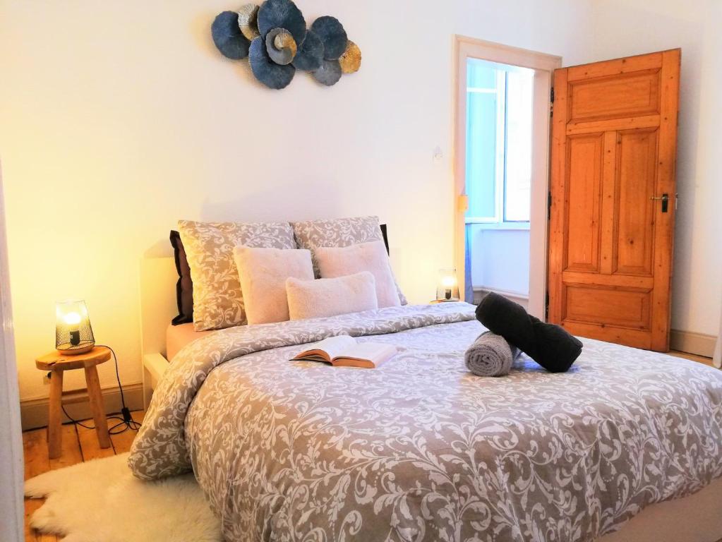 1 dormitorio con 1 cama con libros y reloj en la pared en De 2 à 6 personnes - Le Street'Art - CROISÉE DES PARCS - A 20 minutes de Center Parc et Parc Animalier Sainte-Croix - Netflix - Wifi, en Sarrebourg