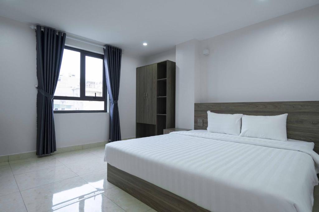 a bedroom with a large white bed and a window at AURORA BÃI CHÁY HẠ LONG in Ha Long