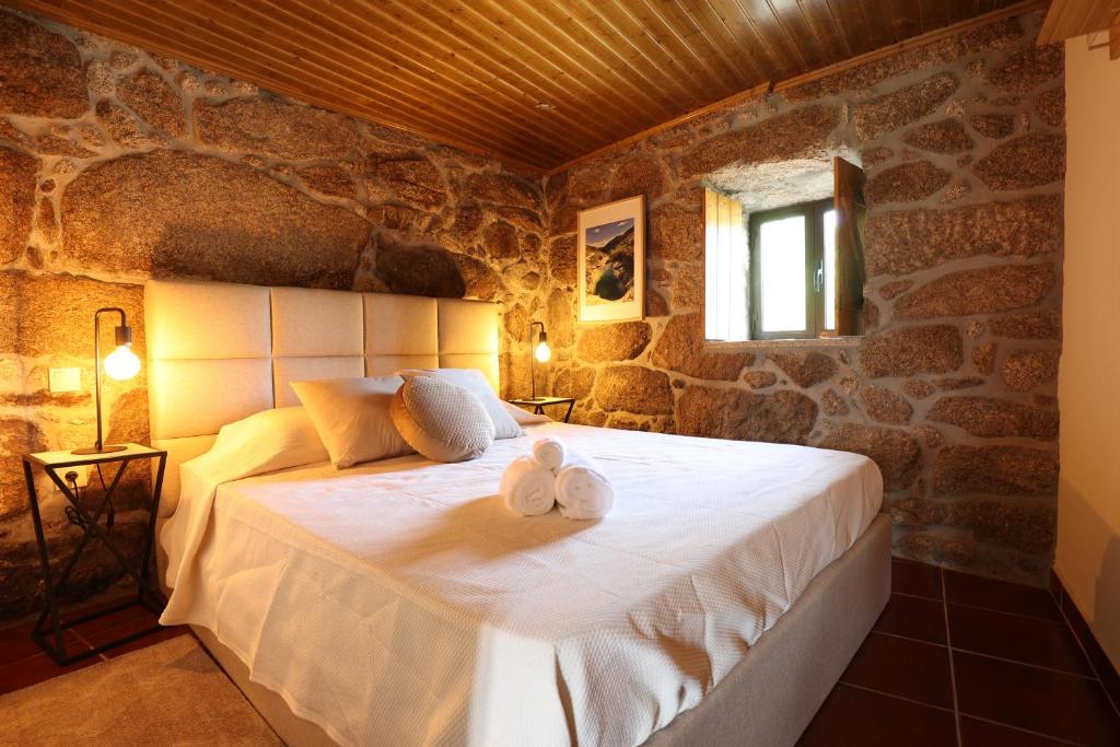 a bedroom with a bed with towels on it at Casa da Cascata in Pincães