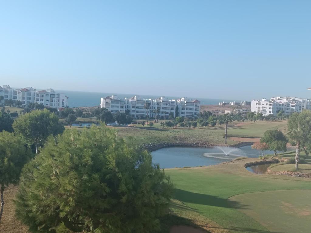 a view of a golf course with a pond at Bel Appart Marina Golf Asilah in Asilah