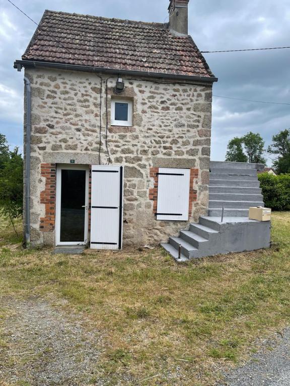 an old stone building with two doors and a window at Maison de campagne in Domeyrot