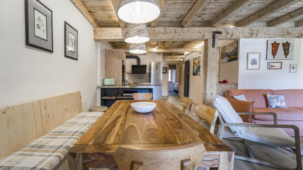 uma sala de estar com uma mesa de madeira e cadeiras em Pleta del Tarter Lodge em El Tarter