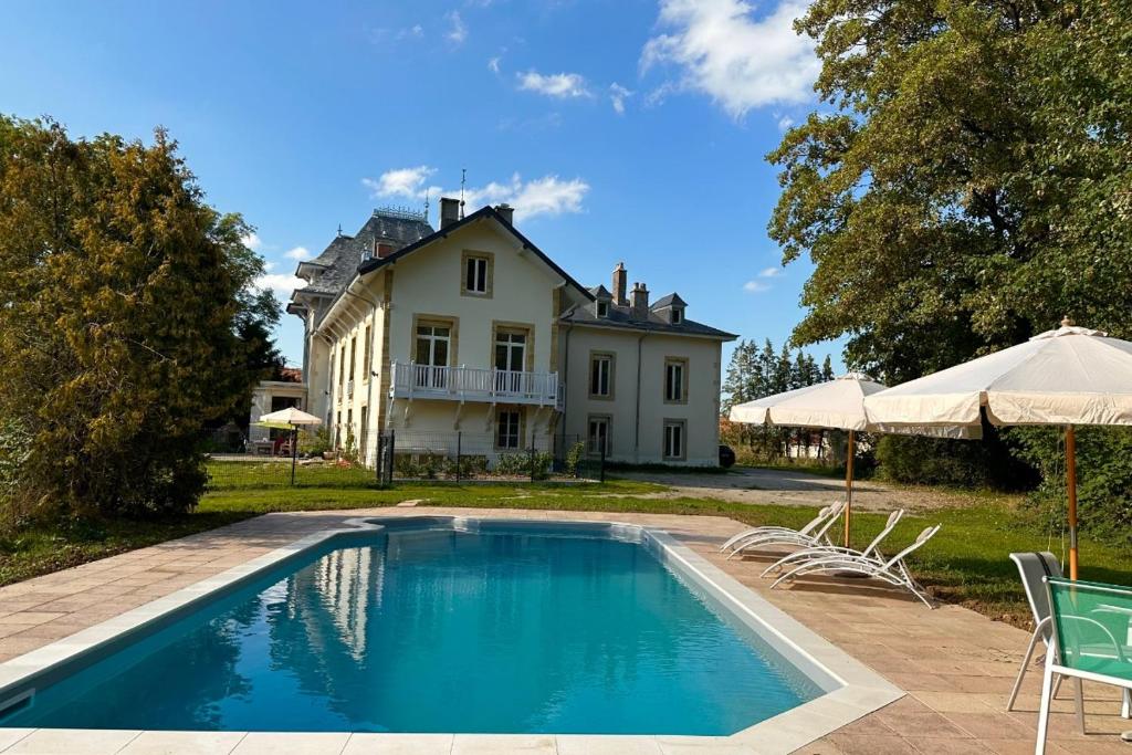 a house with a swimming pool in front of a house at Château Viéndal proche Vittel et Contrexéville in Vaudoncourt