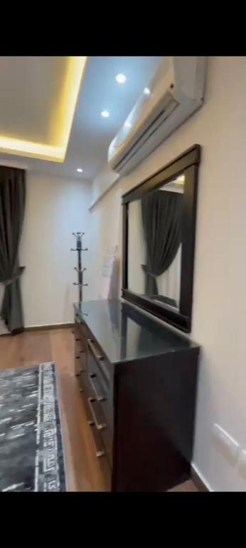 a bathroom with a black counter and a mirror at Golden in Mossadak Tower in Cairo