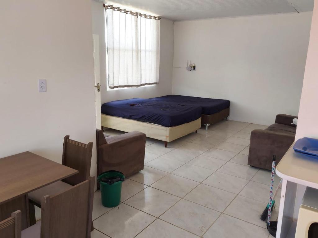 - une chambre avec un lit, une table et des chaises dans l'établissement Casa laranjal, à Pelotas