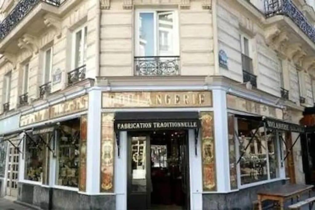 une devanture de magasin d'un immeuble dans une rue dans l'établissement Charmant studio rénové calme triangle d’Or Canal St Martin, à Paris