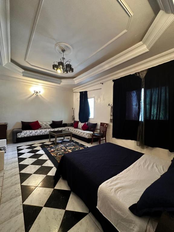 a bedroom with a bed and a checkered floor at Étage RDC villa vu sur mer avec jardin in El Jadida