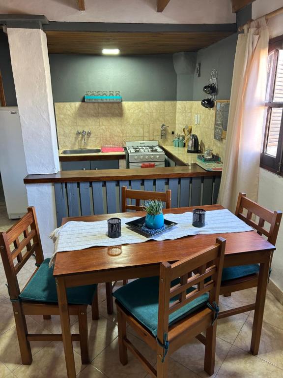 cocina con mesa de madera y 2 sillas en Departamentos Cachita en Carhué