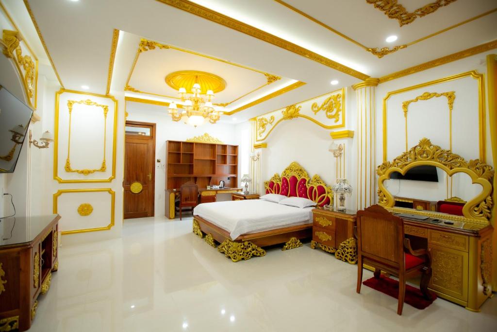 a bedroom with a king sized bed and a desk at KING VILLA QUẢNG NGÃI in Quang Ngai