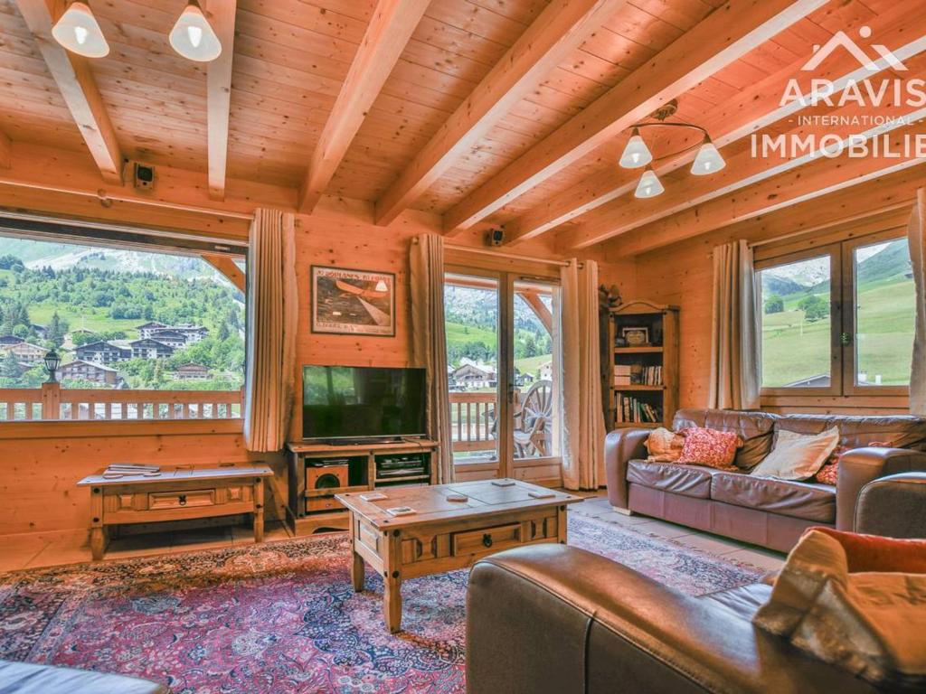 a living room with a couch and a tv at Chalet Le Grand-Bornand, 12 pièces, 20 personnes - FR-1-391-114 in Le Grand-Bornand