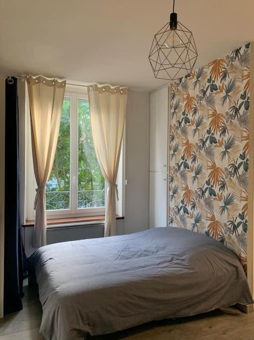 une chambre avec un grand lit et une fenêtre dans l'établissement Grand studio centre ville Saint-Etienne, à Saint-Étienne