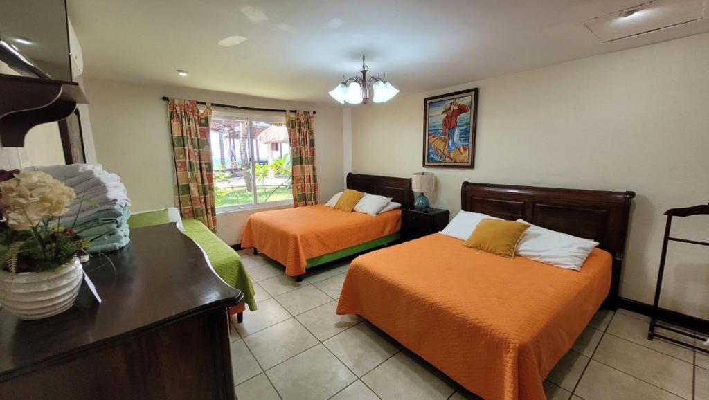 Habitación de hotel con 2 camas y mesa en Hotel Hawaian Paradise, en El Hawaii