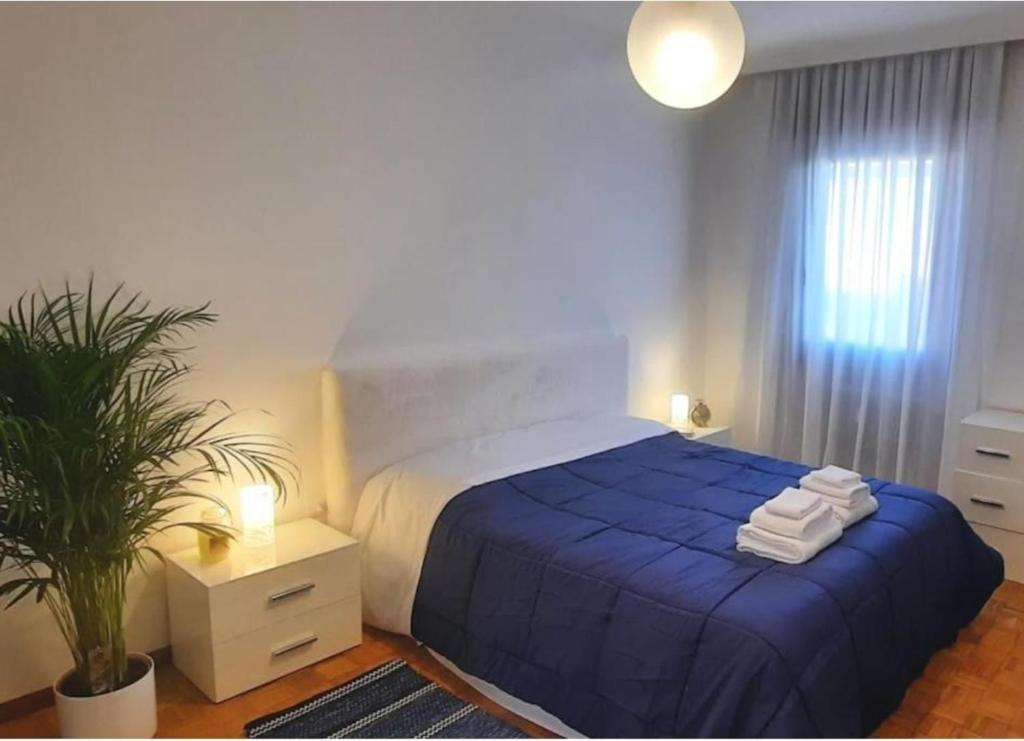 Verdisuite - Trento centro - Parcheggio privato gratuito في ترينتو: غرفة نوم بسرير ازرق عليها مناشف