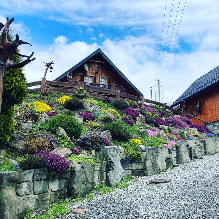 un jardín frente a una casa con flores en Przystanek Beskidy, en Brenna