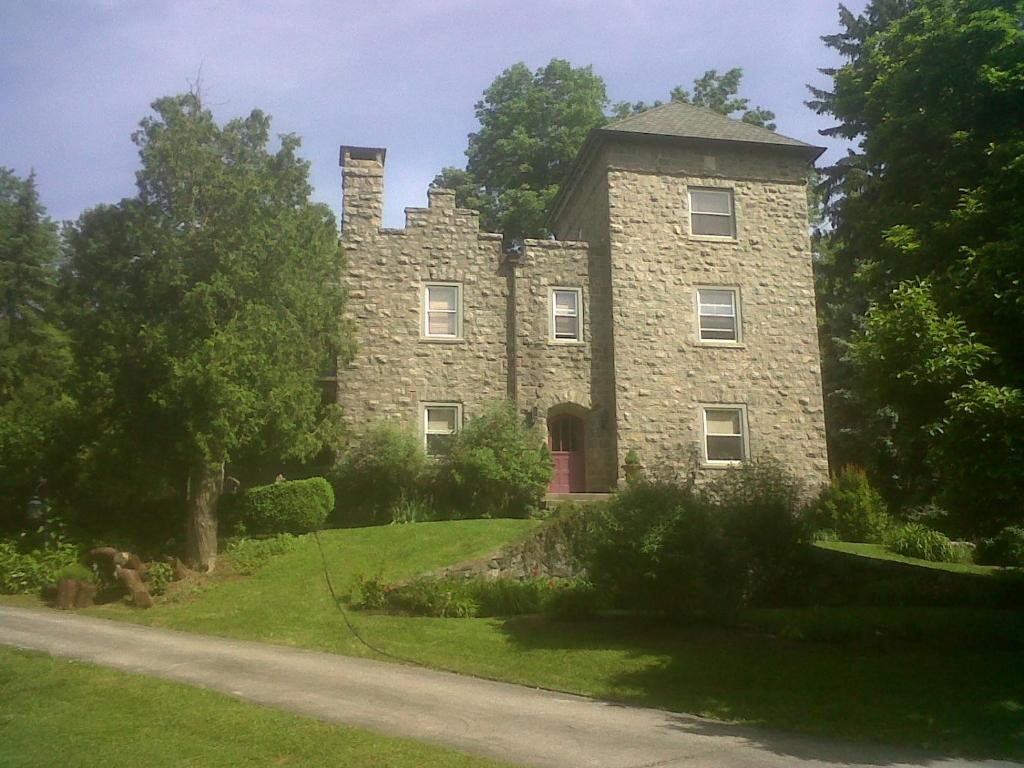 uma velha casa de pedra ao lado de uma estrada em Little Castle em Villanova
