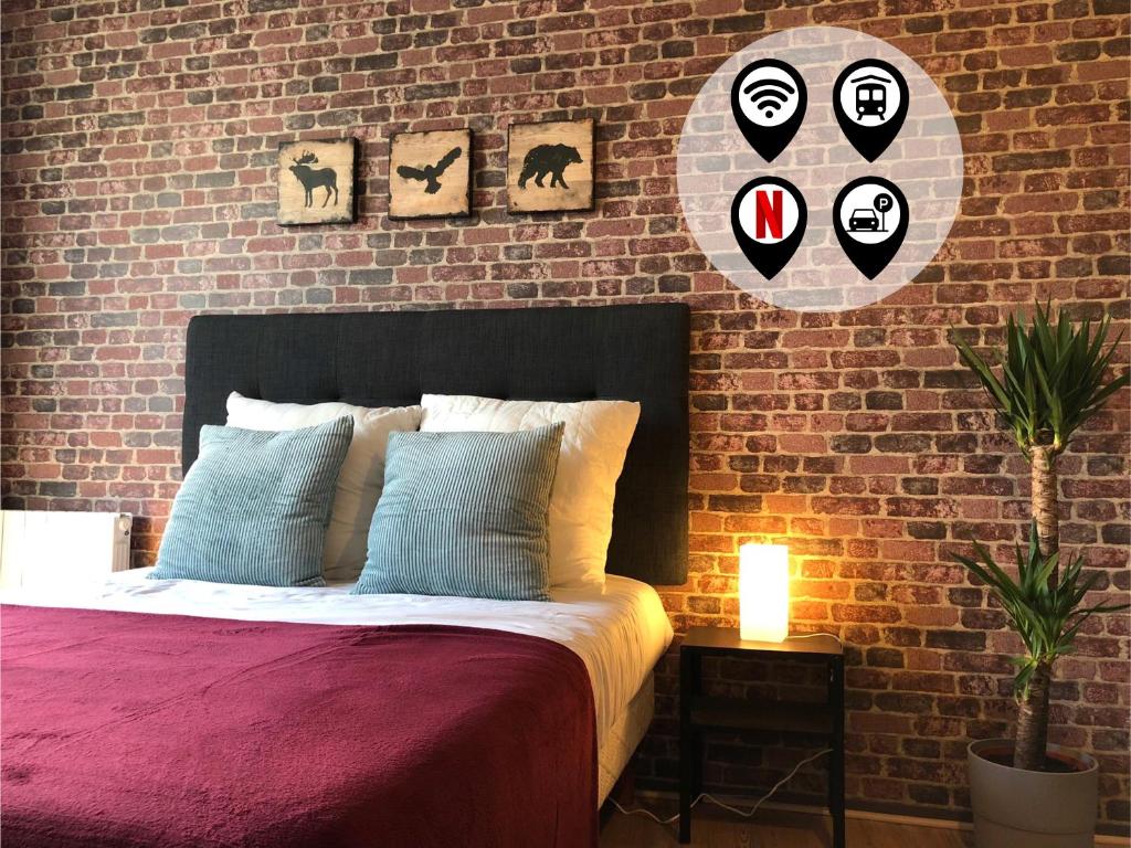 a bedroom with a bed and a brick wall at Studio avec balcon & parking gratuit - Tours Gare in Tours