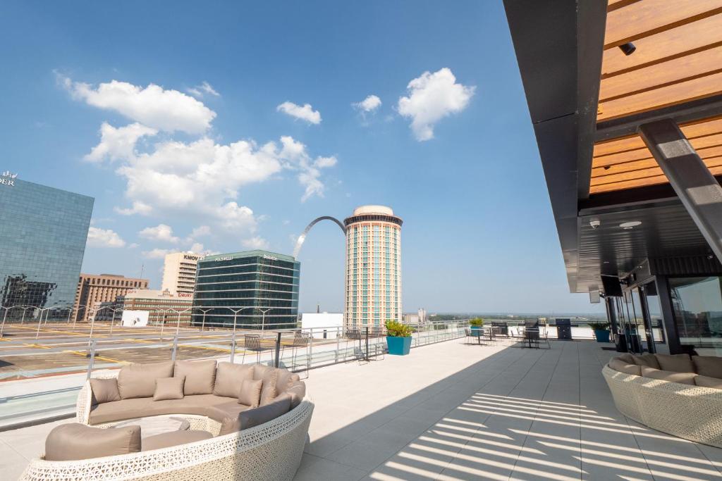 a balcony with two chairs on top of a building at Ballpark Luxury Loft steps from Arch in Saint Louis