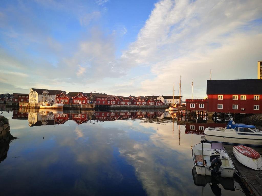 a body of water with boats in a harbor at Kule gule huset in Svolvær