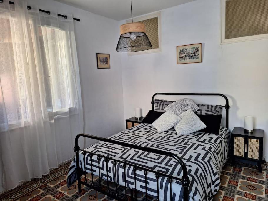 Un dormitorio con una cama con un edredón blanco y negro. en Self Contained City Apartment, en Perpiñán