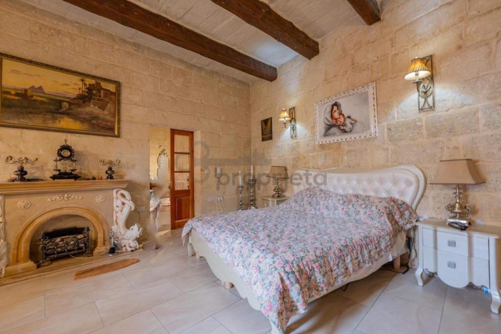 1 dormitorio con 1 cama y chimenea en Vintage farmhouse en Qormi