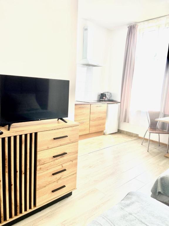 a living room with a television on a wooden dresser at DOMAX in Legnica