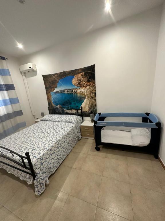 a bedroom with two beds and a painting on the wall at Casa Cinisi - Casa Vacanze in Cinisi