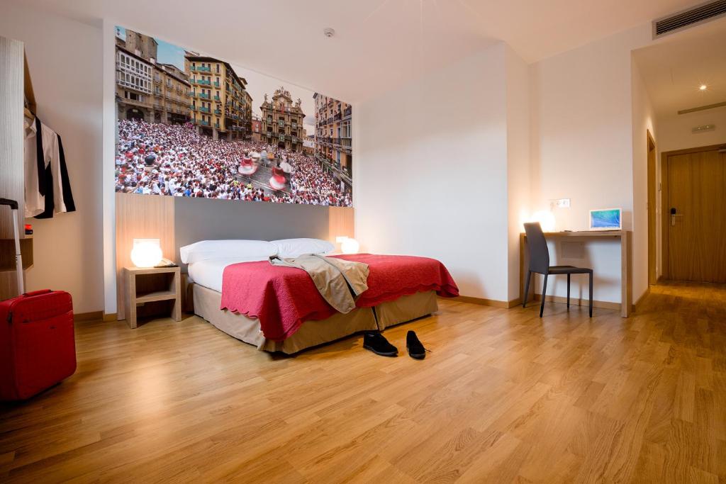 a bedroom with a bed and a painting of a soccer game at IRAIPE Pamplona Hostal in Pamplona