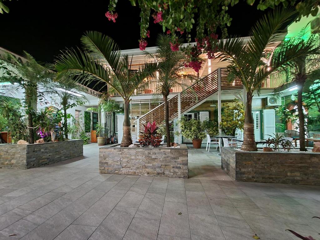 a house with palm trees in a courtyard at night at Hotel CHEZ PAPA DAYA in Saint-Pierre