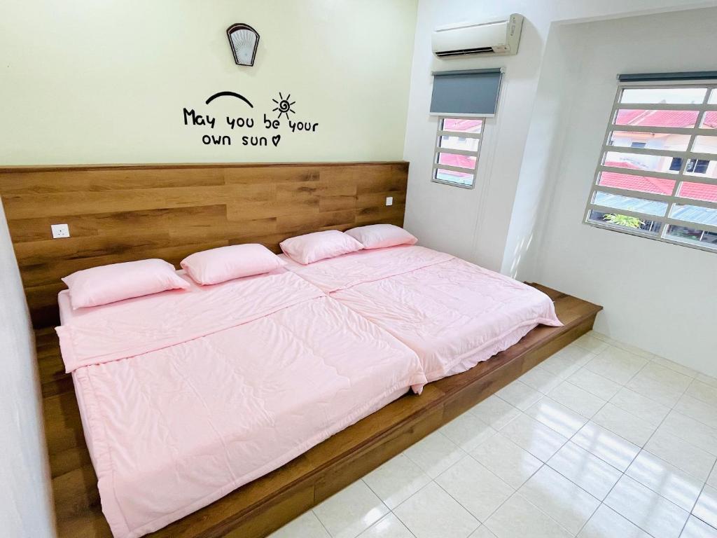 Bett in einem Zimmer mit rosa Bettwäsche und Kissen in der Unterkunft EE Summer Guest House 3.0 in Seremban