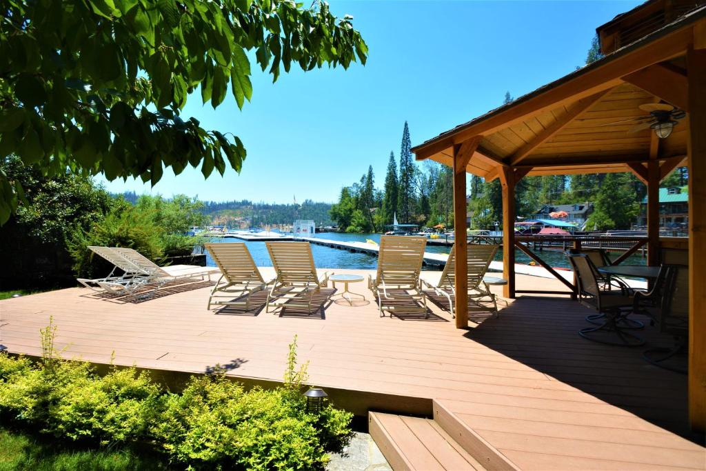 una terraza de madera con sillas y cenador en Beautiful Lake Front home with gazebo - Johnson, en Bass Lake
