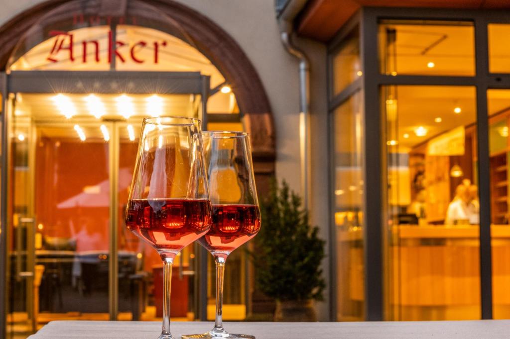 two glasses of wine sitting on top of a table at Hotel & Weinhaus Anker in Marktheidenfeld