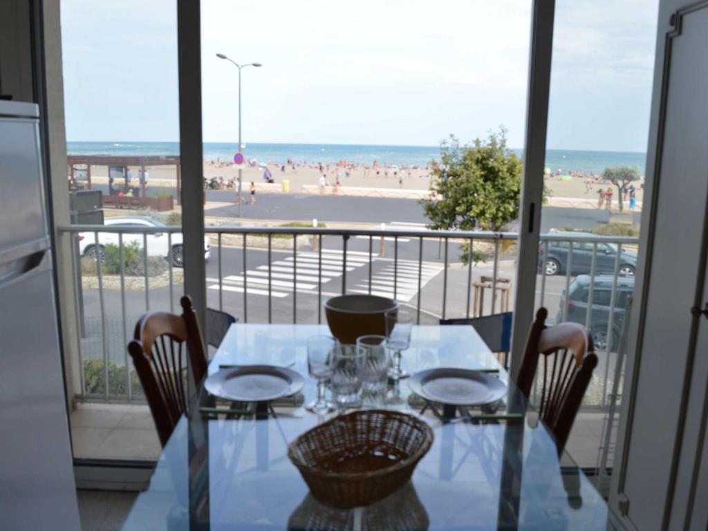 une table et des chaises avec vue sur la plage dans l'établissement Studio face à la mer, balcon et local à vélo, 300m du centre - Narbonne Plage - FR-1-229B-61, à Narbonne